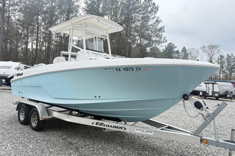 Slide: The Image of 2022 Wellcraft 222 Fisherman boat on trailer, parked outdoors with trees in background. - 4