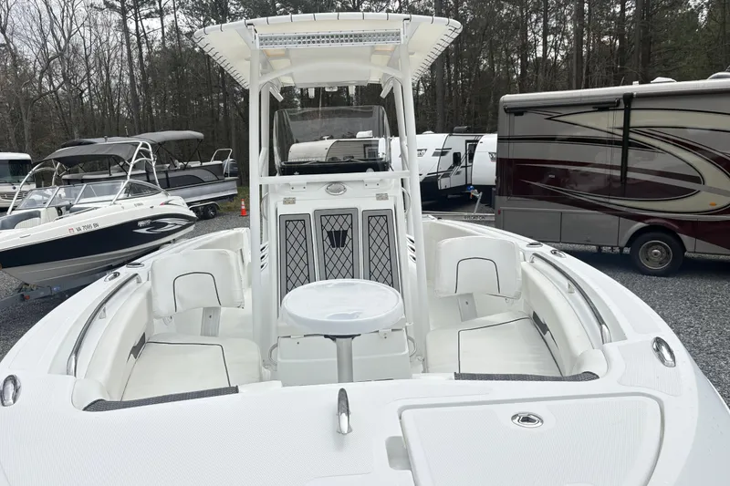 Slide: The Image of 2022 Wellcraft 222 Fisherman boat with spacious seating, parked among other boats and RVs. - 5