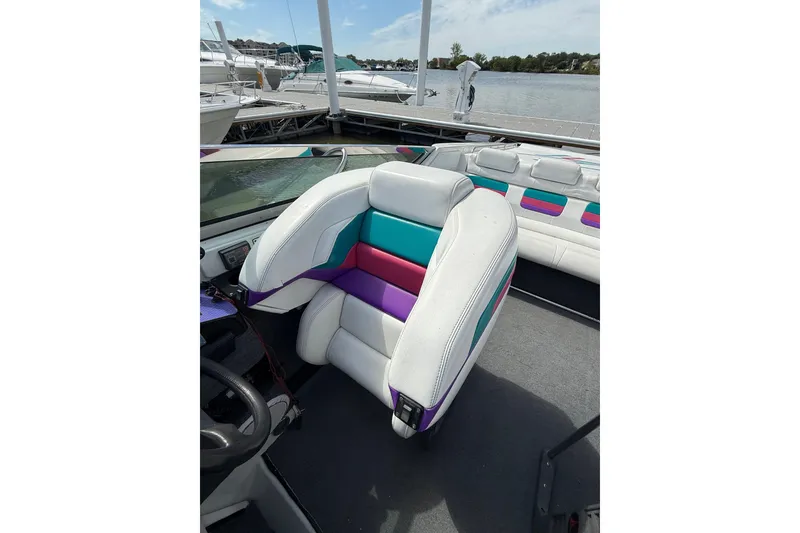 Slide: The Image of 1994 Formula 419 SR-1 boat interior with colorful seating at a marina. - 28