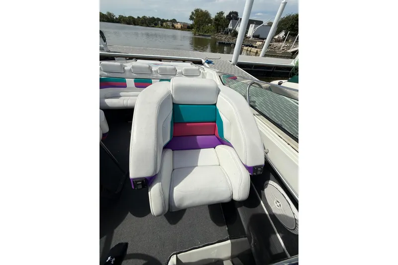 Slide: The Image of 1994 Formula 419 SR-1 boat interior with colorful seating by the water. - 9