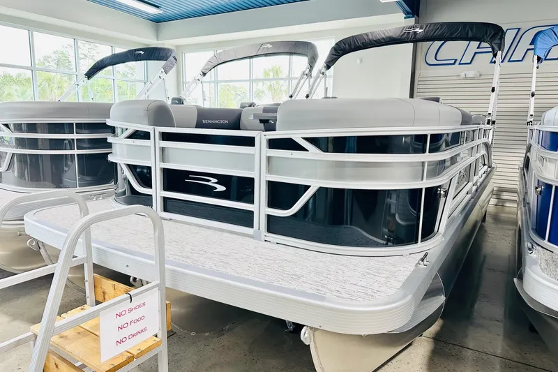 The Image of 2026 Bennington 22 SSR pontoon boat displayed in a showroom. - 1
