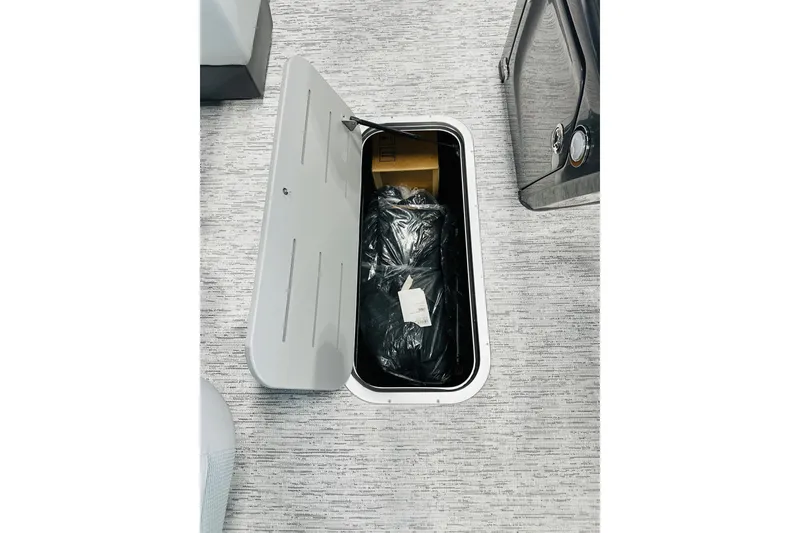 Slide: The Image of Open storage compartment on 2026 Bennington 22 SSR boat, revealing interior contents. - 9