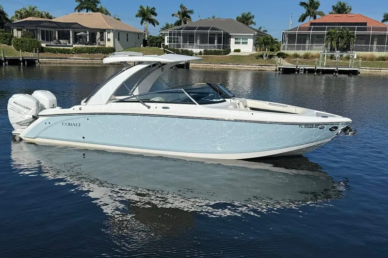 The Image of 2018 Cobalt 30SC boat on calm water, with waterfront homes in the background. - 0