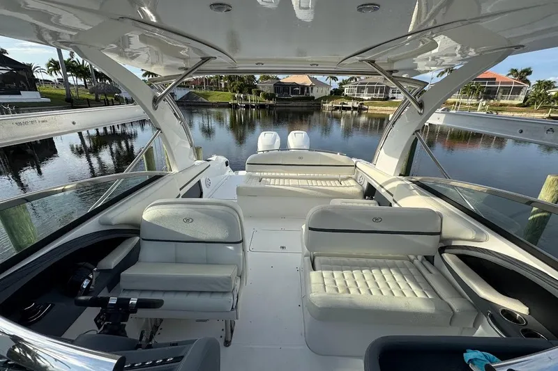 Slide: The Image of 2018 Cobalt 30SC boat interior with luxurious seating, docked by a serene waterfront. - 19
