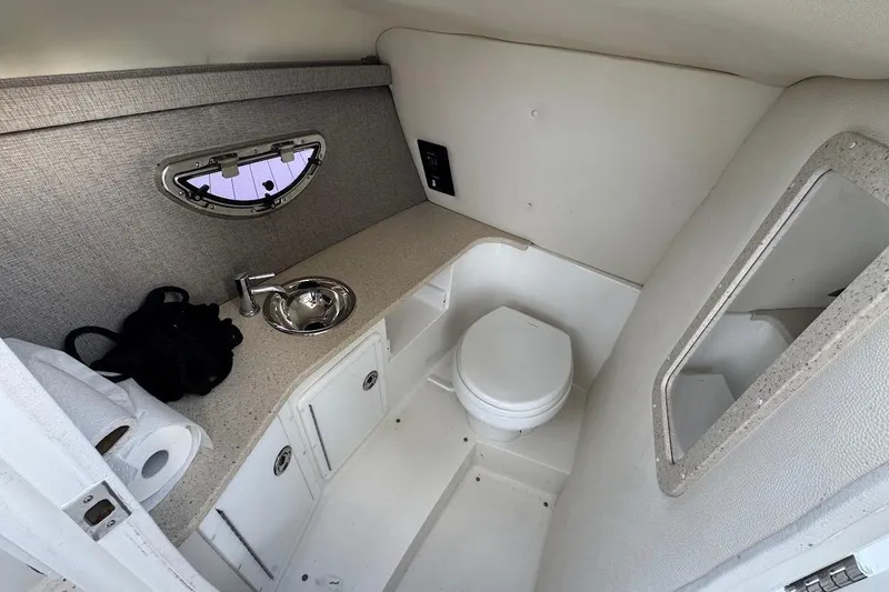 Slide: The Image of 2018 Cobalt 30SC boat interior with compact bathroom, sink, and window. - 24