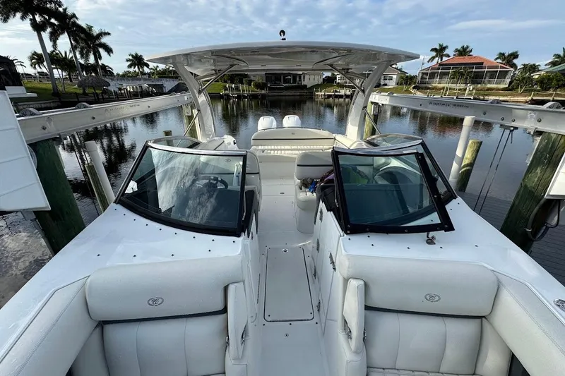 Slide: The Image of 2018 Cobalt 30SC boat with white interior, docked in a scenic waterfront setting. - 25