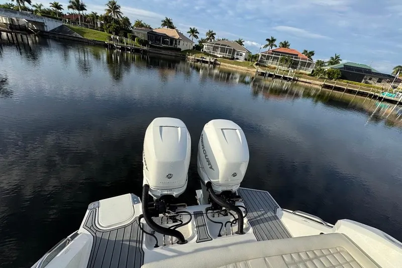 Slide: The Image of 2018 Cobalt 30SC boat with dual Mercury outboard engines on a calm waterfront. - 30
