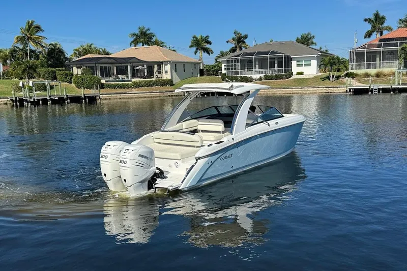 Slide: The Image of 2018 Cobalt 30SC boat cruising on a calm lake near waterfront homes. - 4