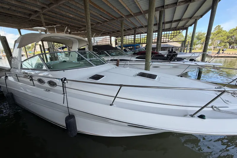 The Image of 2000 Sea Ray Sundancer 310 docked under a covered marina, showcasing sleek design. - 0