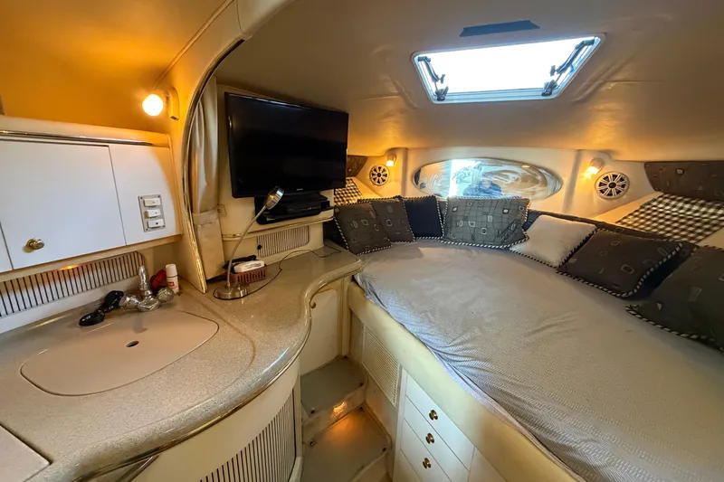 Slide: The Image of Interior of 2000 Sea Ray Sundancer 310 with cozy bed, TV, and kitchenette. - 13