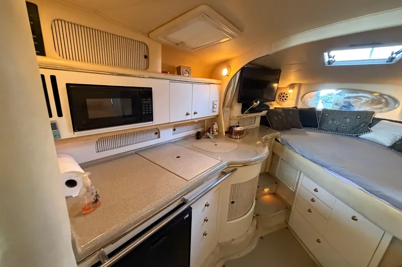 Slide: The Image of Interior of 2000 Sea Ray Sundancer 310 yacht with kitchenette and cozy sleeping area. - 16