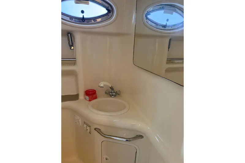 Slide: The Image of Bathroom sink area in 2000 Sea Ray Sundancer 310 yacht with oval window. - 18