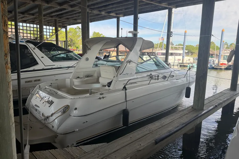 Slide: The Image of 2000 Sea Ray Sundancer 310 docked in a marina, showcasing sleek design and spacious deck. - 4