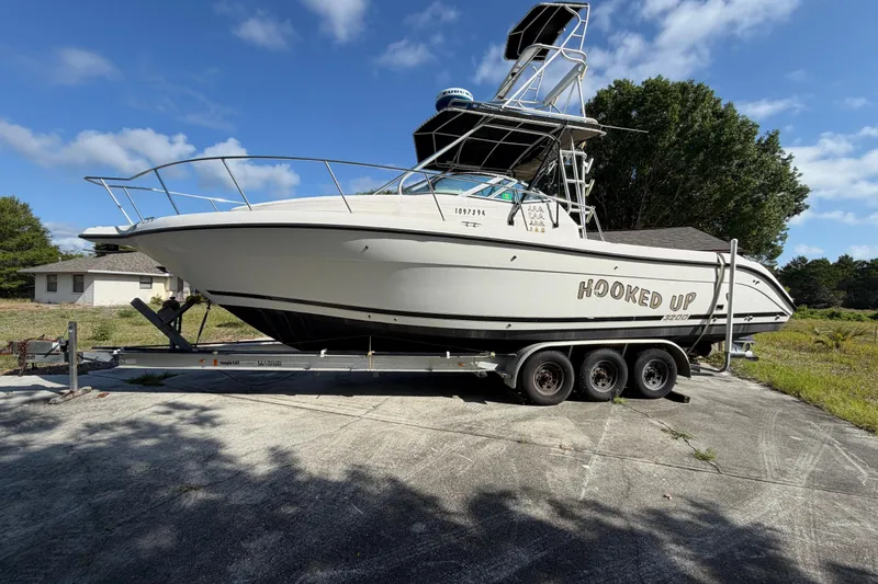 The Image of Century 3200 Walk-Around 2000 boat on trailer, labeled "Hooked Up," parked outdoors. - 0