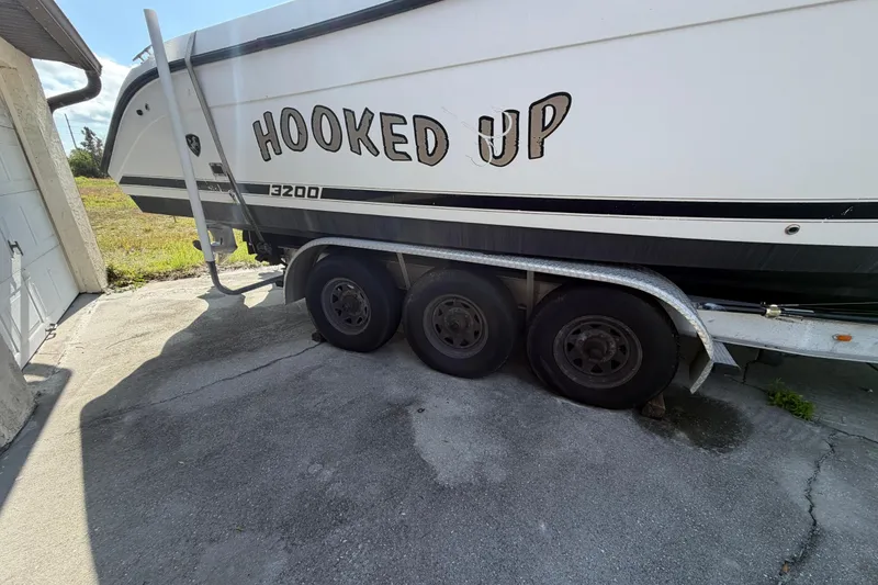 Slide: The Image of Century 3200 Walk-Around boat on trailer, labeled "Hooked Up," parked on concrete. - 16