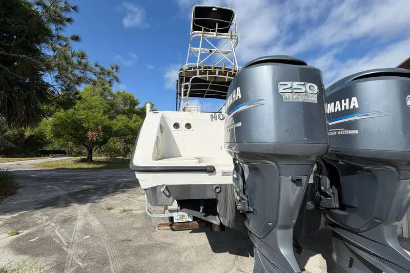 Slide: The Image of Century 3200 Walk-Around boat with twin Yamaha 250 engines, parked outdoors. - 25