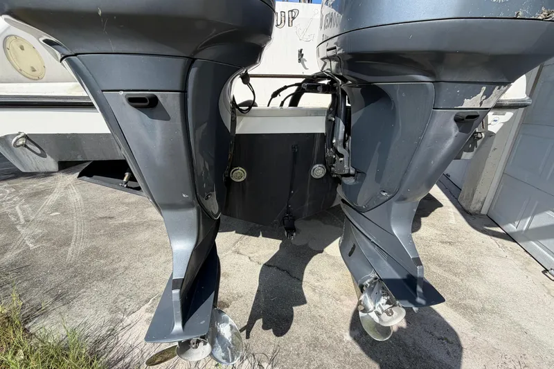 Slide: The Image of Twin outboard motors on a 2000 Century 3200 Walk-Around boat, parked on concrete. - 26