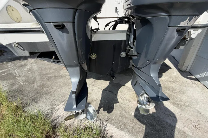 Slide: The Image of Twin outboard motors on a 2000 Century 3200 Walk-Around boat, parked on concrete. - 27