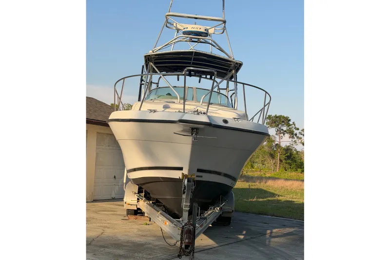 Slide: The Image of 2000 Century 3200 Walk-Around boat on trailer, parked outdoors. - 3