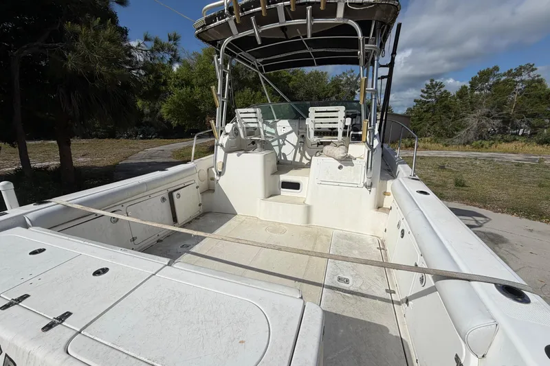 Slide: The Image of 2000 Century 3200 Walk-Around boat with spacious deck and seating, surrounded by trees. - 32