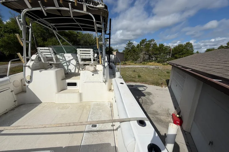 Slide: The Image of 2000 Century 3200 Walk-Around boat docked, featuring spacious deck and seating area. - 34