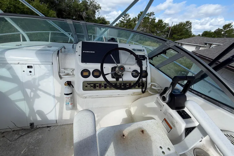 Slide: The Image of Cockpit of 2000 Century 3200 Walk-Around boat with steering wheel and control panel. - 43