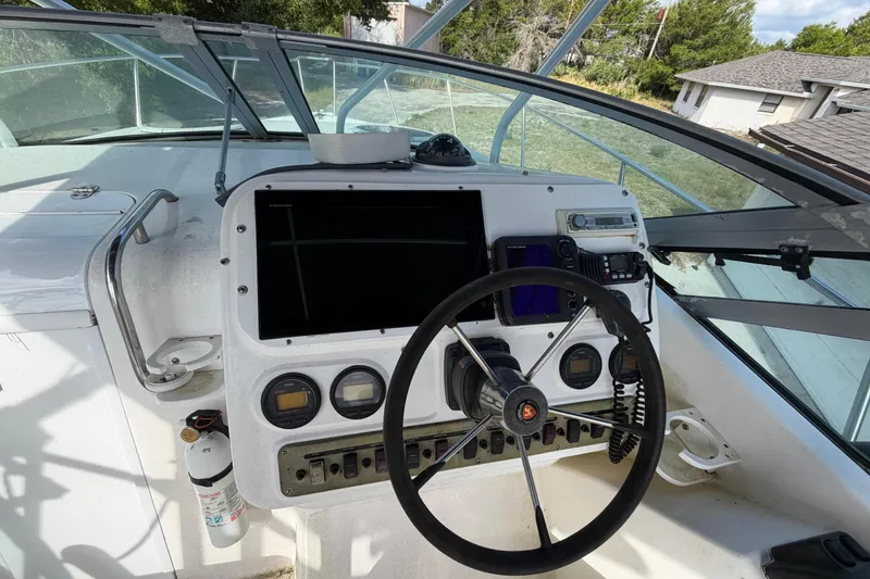 Slide: The Image of Century 3200 Walk-Around 2000 boat dashboard with steering wheel and navigation instruments. - 47