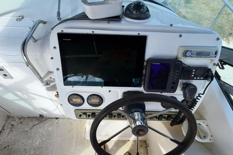 Slide: The Image of Century 3200 Walk-Around 2000 boat dashboard with steering wheel and navigation equipment. - 48