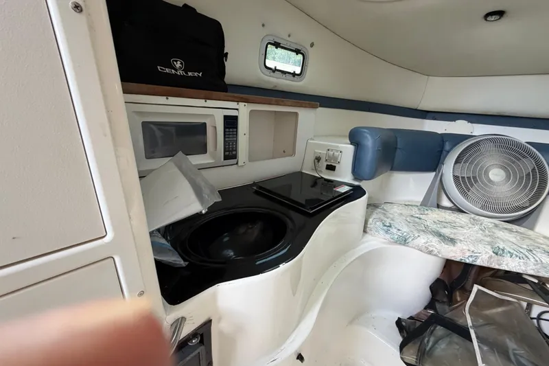 Slide: The Image of Interior of a 2000 Century 3200 Walk-Around boat with kitchenette and seating area. - 55
