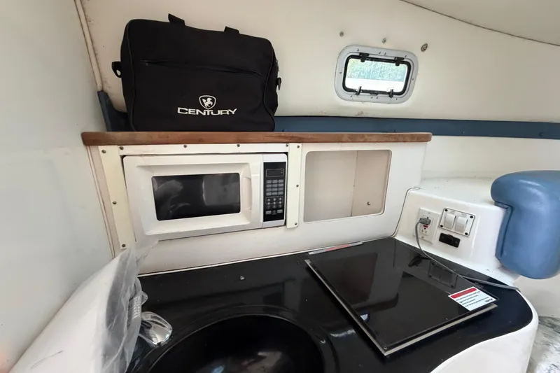 Slide: The Image of Compact kitchen area in a 2000 Century 3200 Walk-Around boat with microwave and stove. - 56