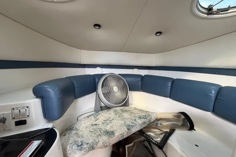 Slide: The Image of Interior of 2000 Century 3200 Walk-Around boat with blue seating and fan. - 57