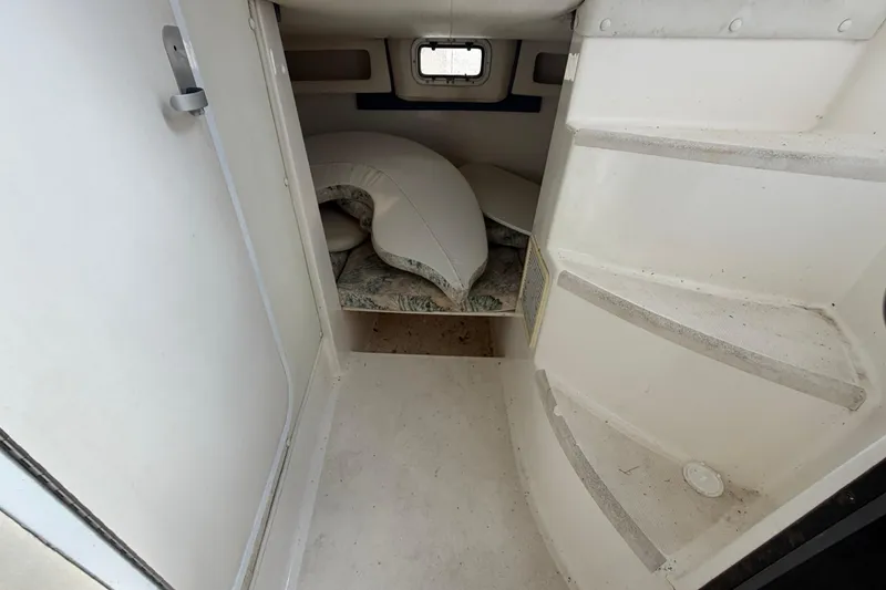 Slide: The Image of Interior cabin of a 2000 Century 3200 Walk-Around boat, featuring compact sleeping area. - 58