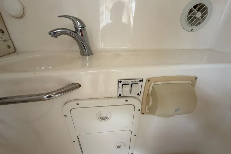 Slide: The Image of Interior of a 2000 Century 3200 Walk-Around boat, featuring a sink and control panel. - 64