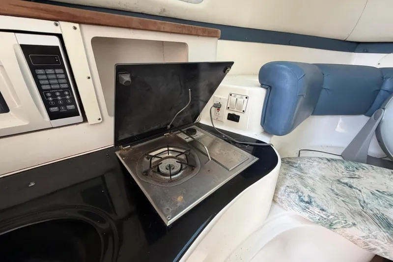 Slide: The Image of Interior of a 2000 Century 3200 Walk-Around boat with stove and seating area. - 68