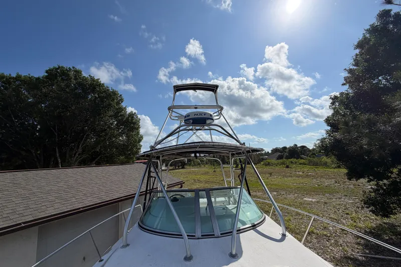 Slide: The Image of 2000 Century 3200 Walk-Around boat under clear blue sky with trees in background. - 71