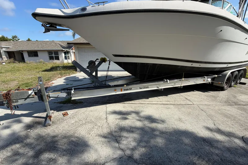 Slide: The Image of Century 3200 Walk-Around boat on trailer, parked in driveway, sunny day. - 8
