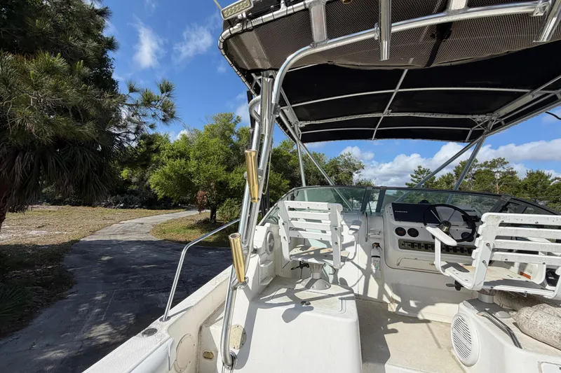 Slide: The Image of Century 3200 Walk-Around boat, 2000 model, with helm and seating, surrounded by trees. - 81