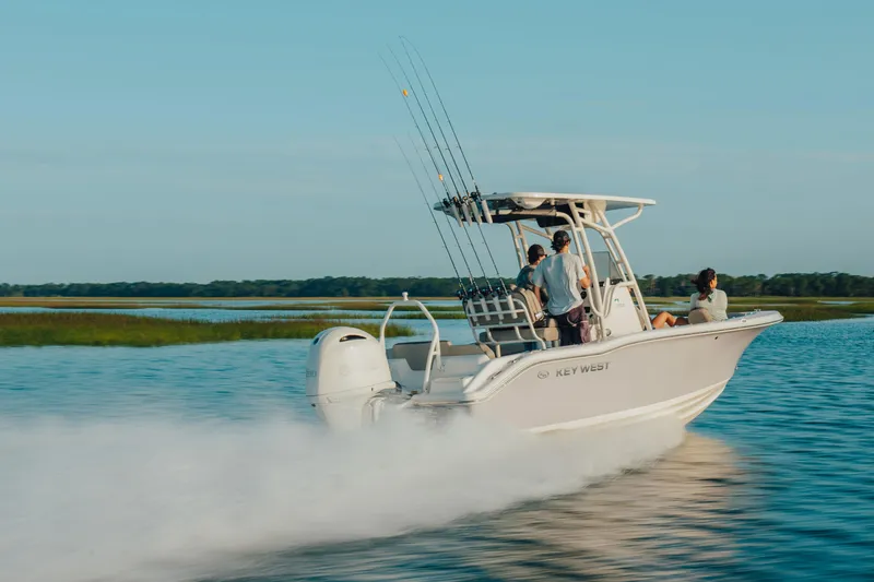 Slide: The Image of 2026 Key West 239 FS boat cruising on a serene lake with passengers enjoying the ride. - 10
