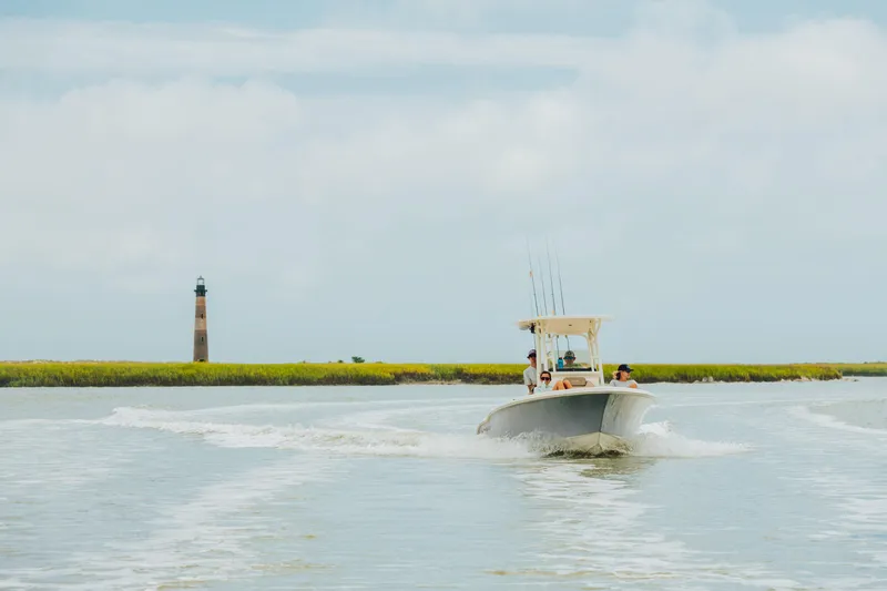 Slide: The Image of 2026 Key West 239 FS boat cruising near a lighthouse on a sunny day. - 13