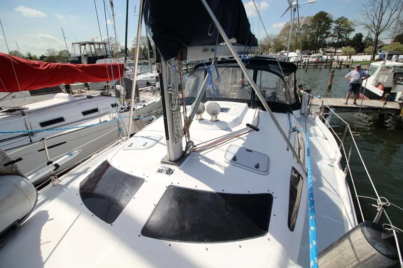 Slide: The Image of 1999 Hunter 410 sailboat docked at marina, featuring sleek deck design and rigging. - 14