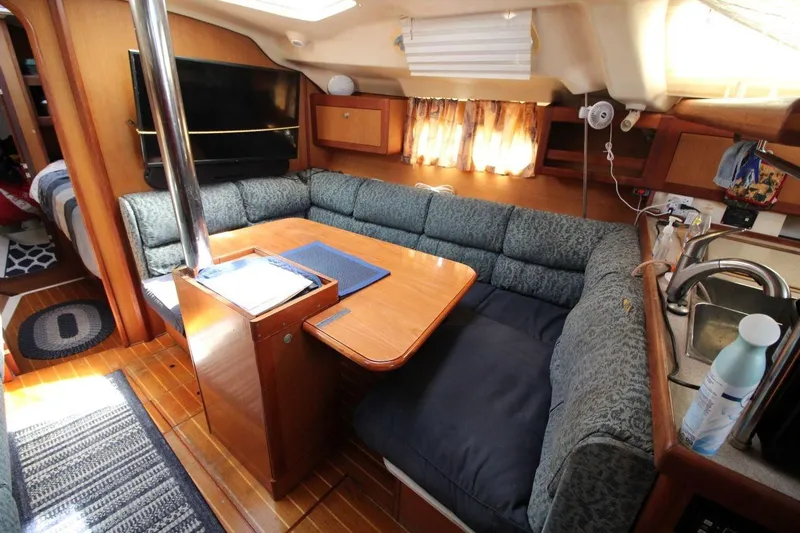 Slide: The Image of Interior of a 1999 Hunter 410 sailboat with cozy seating and wooden finishes. - 17