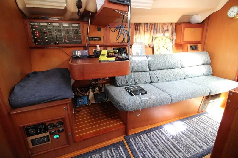 Slide: The Image of Interior of a 1999 Hunter 410 sailboat with control panel and seating area. - 18