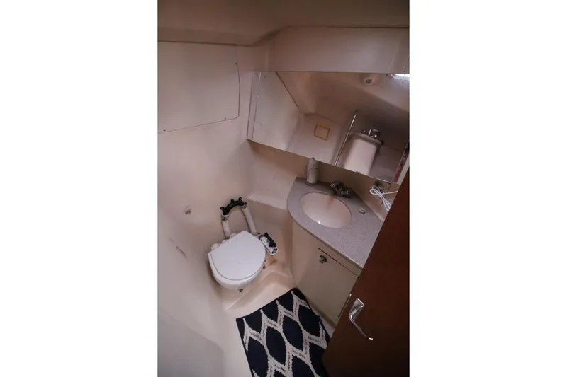 Slide: The Image of Compact bathroom in a 1999 Hunter 410 sailboat, featuring a toilet and sink. - 21