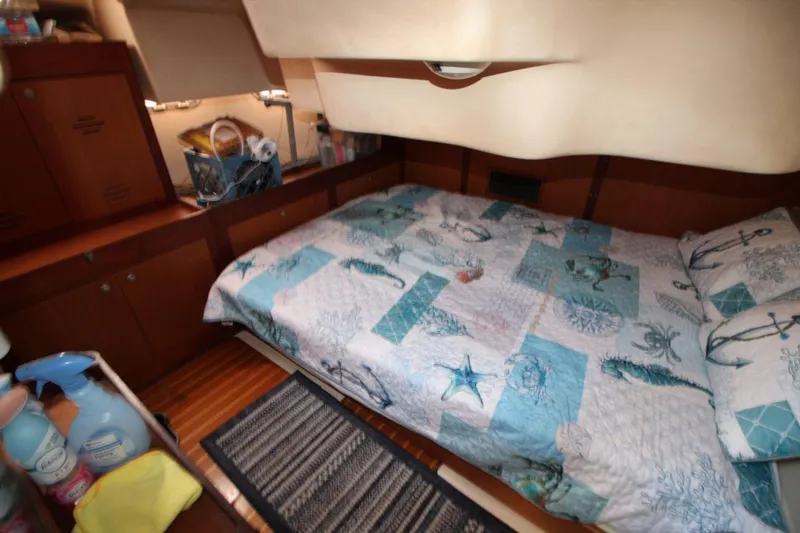 Slide: The Image of Cozy cabin interior of 1999 Hunter 410 yacht with nautical-themed bedding. - 23