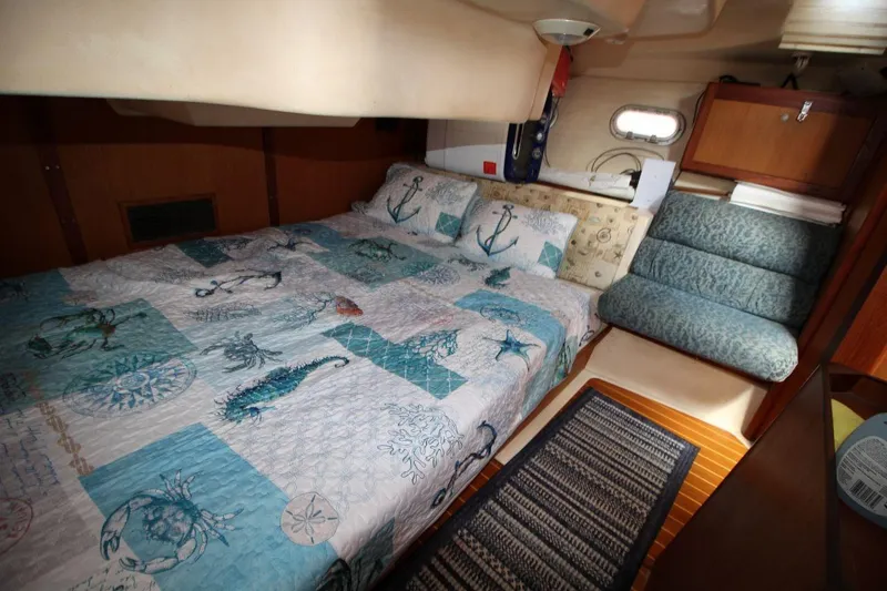 Slide: The Image of Cozy cabin interior of a 1999 Hunter 410 sailboat with nautical-themed bedding. - 24