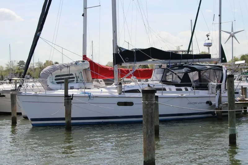 Slide: The Image of Sailboat docked in marina, 1999 Hunter 410 model, with covered deck and visible masts. - 3