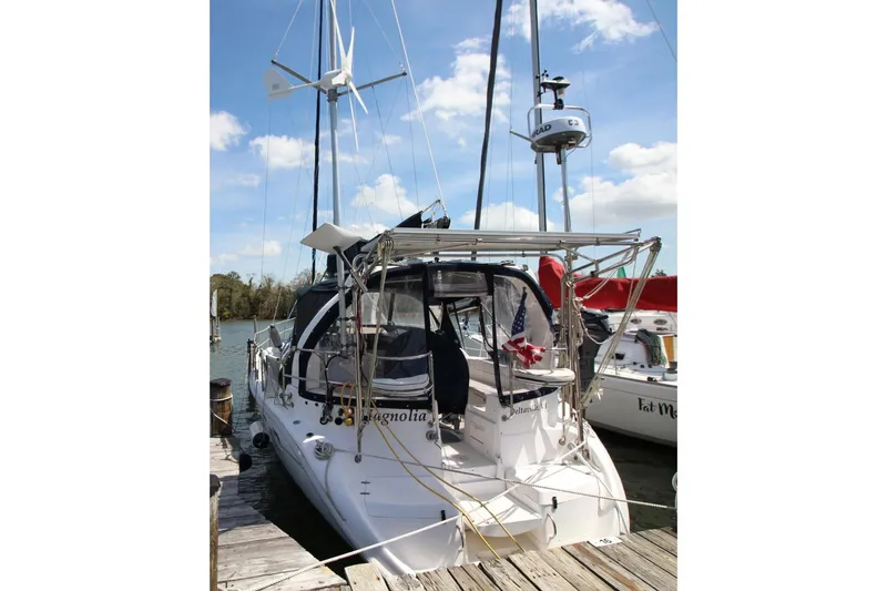 Slide: The Image of Sailboat docked at marina, Hunter 410 model, 1999, with wind turbine and American flag. - 4