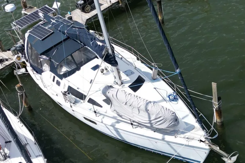 Slide: The Image of Aerial view of a 1999 Hunter 410 sailboat docked, featuring solar panels and covered sails. - 9