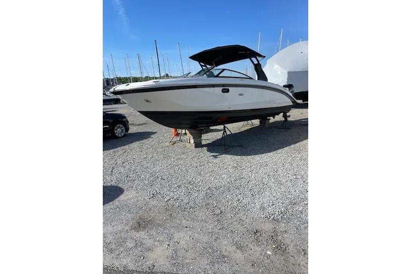 Slide: The Image of 2018 Sea Ray SDX 290 Outboard boat on gravel lot, under clear blue sky. - 18