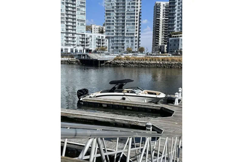 Slide: The Image of 2018 Sea Ray SDX 290 Outboard docked near modern waterfront buildings. - 6